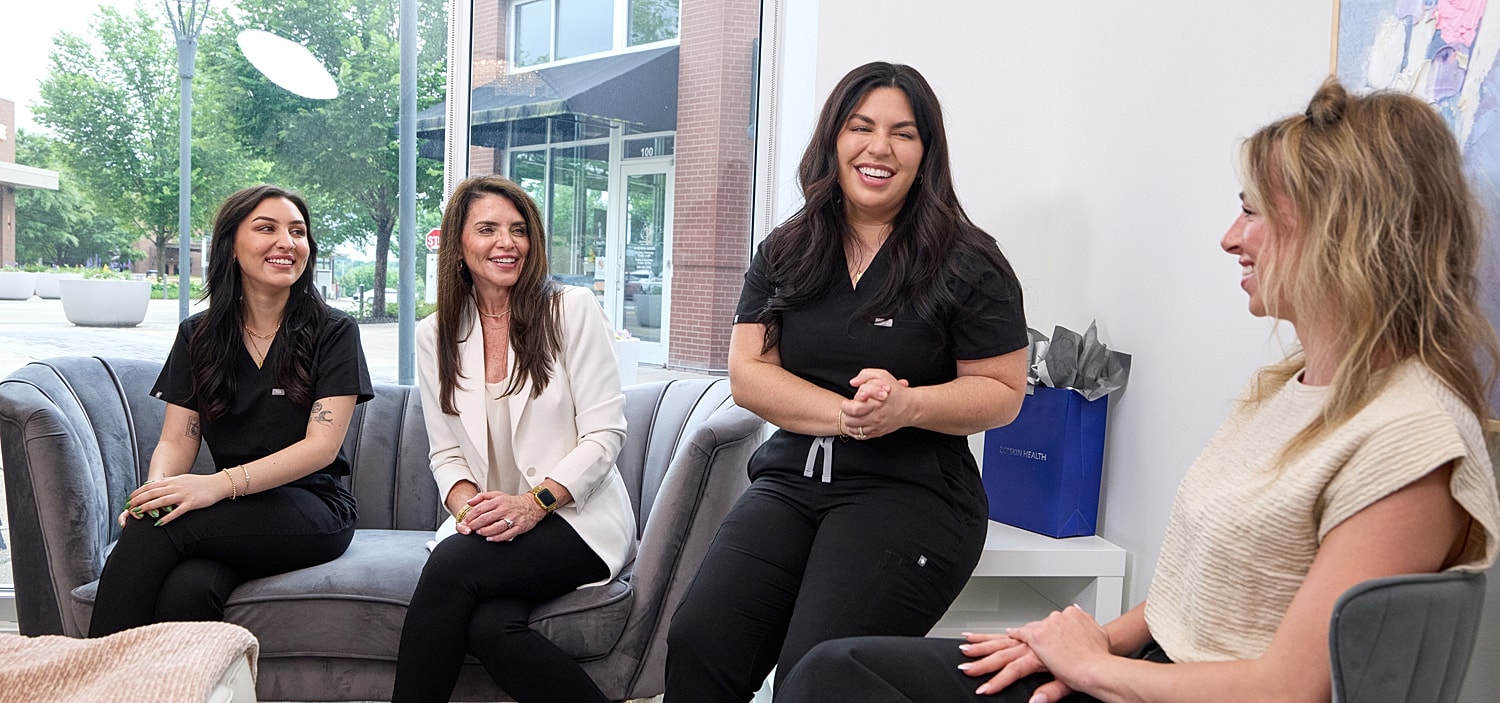 Women chatting in a modern salon setting.