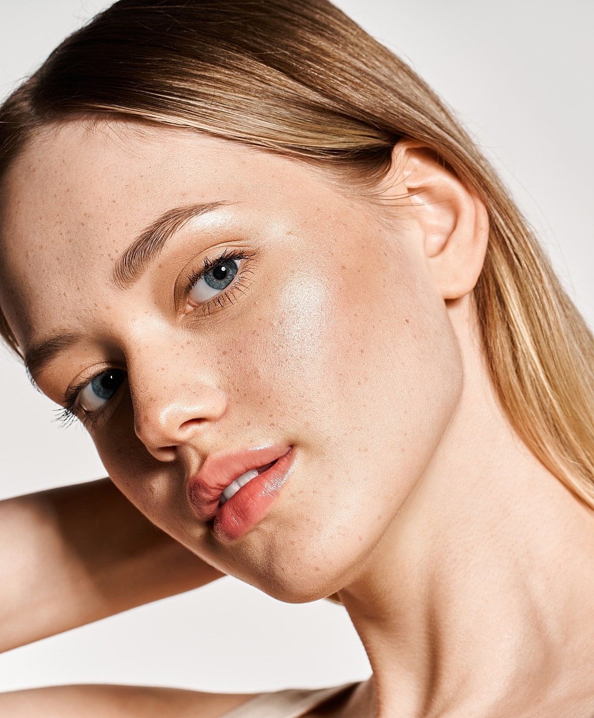 Close-up portrait of a young woman with freckles.