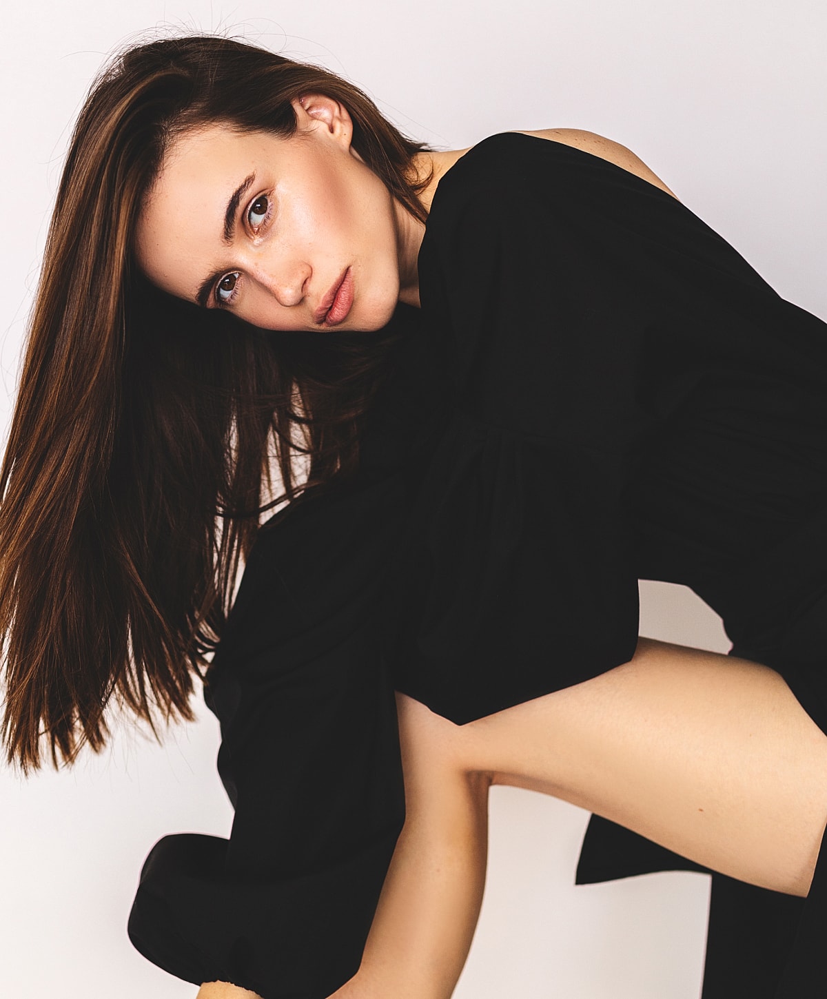 Woman in black outfit posing gracefully.