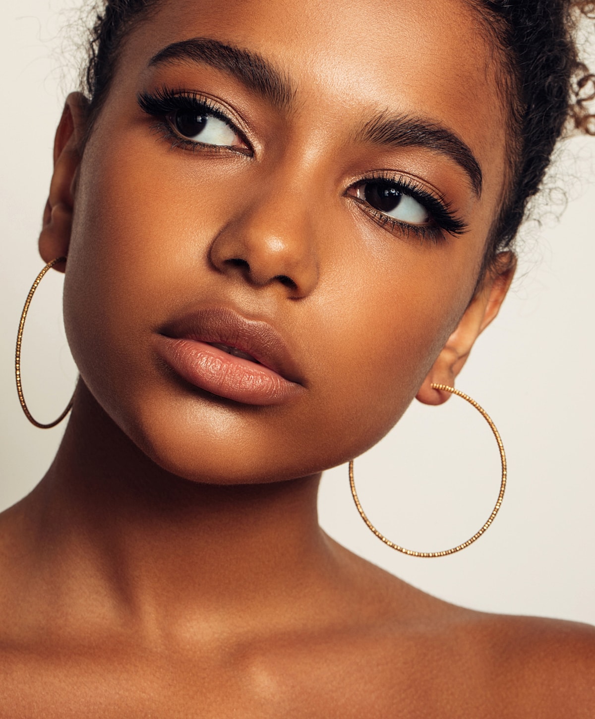 Close-up of a model with hoop earrings.