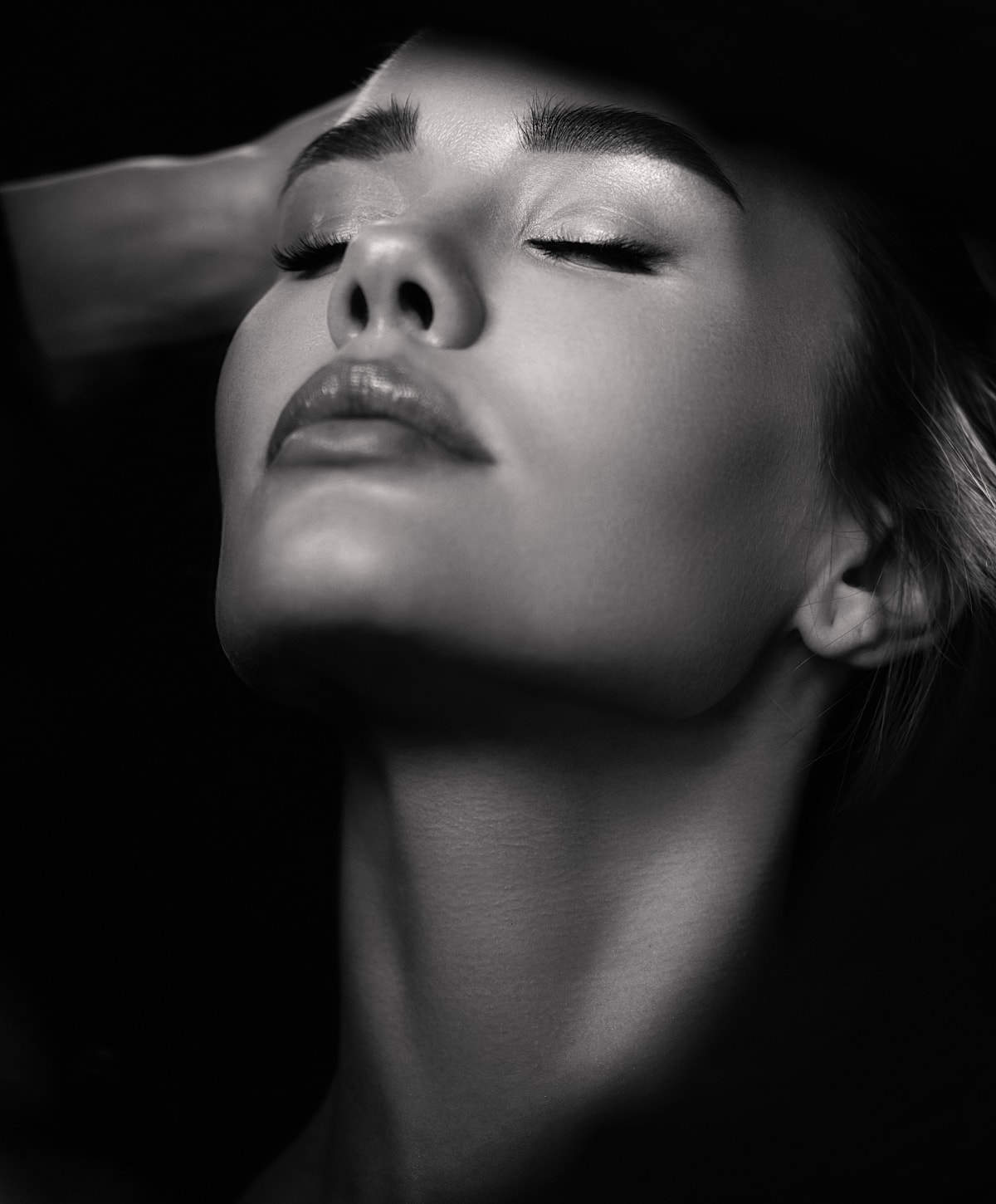 Close-up of serene woman in black and white.