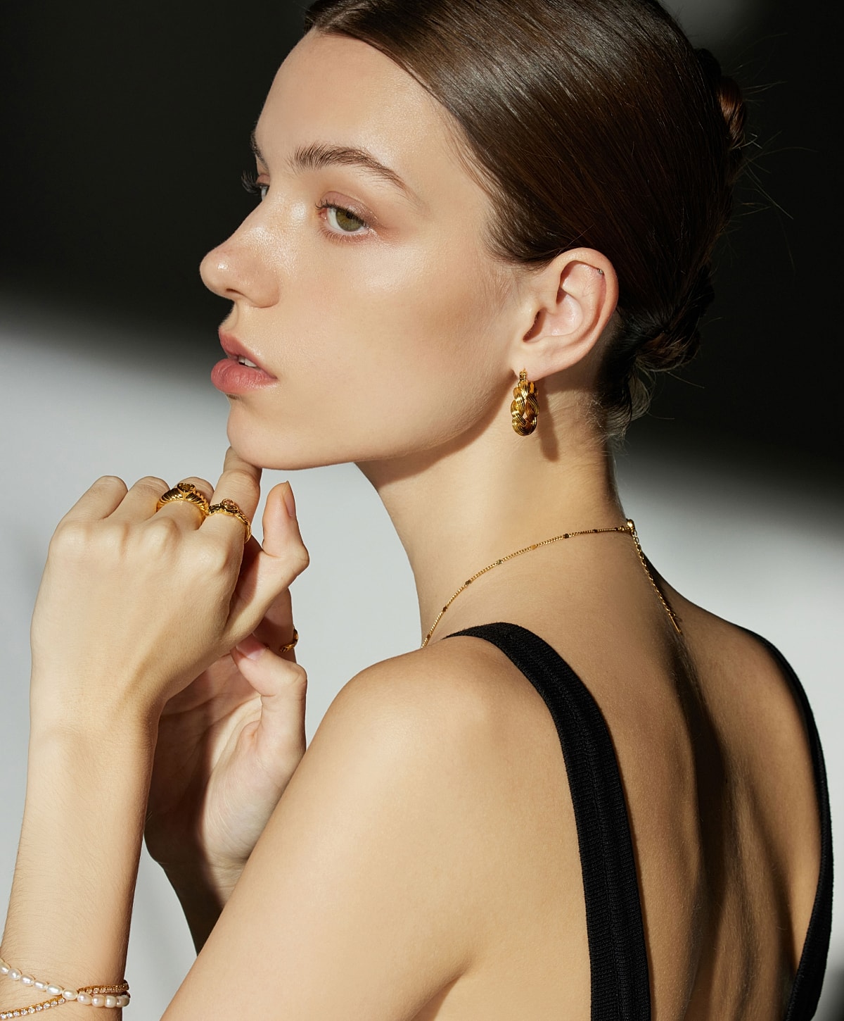 Model showcasing elegant gold jewelry.