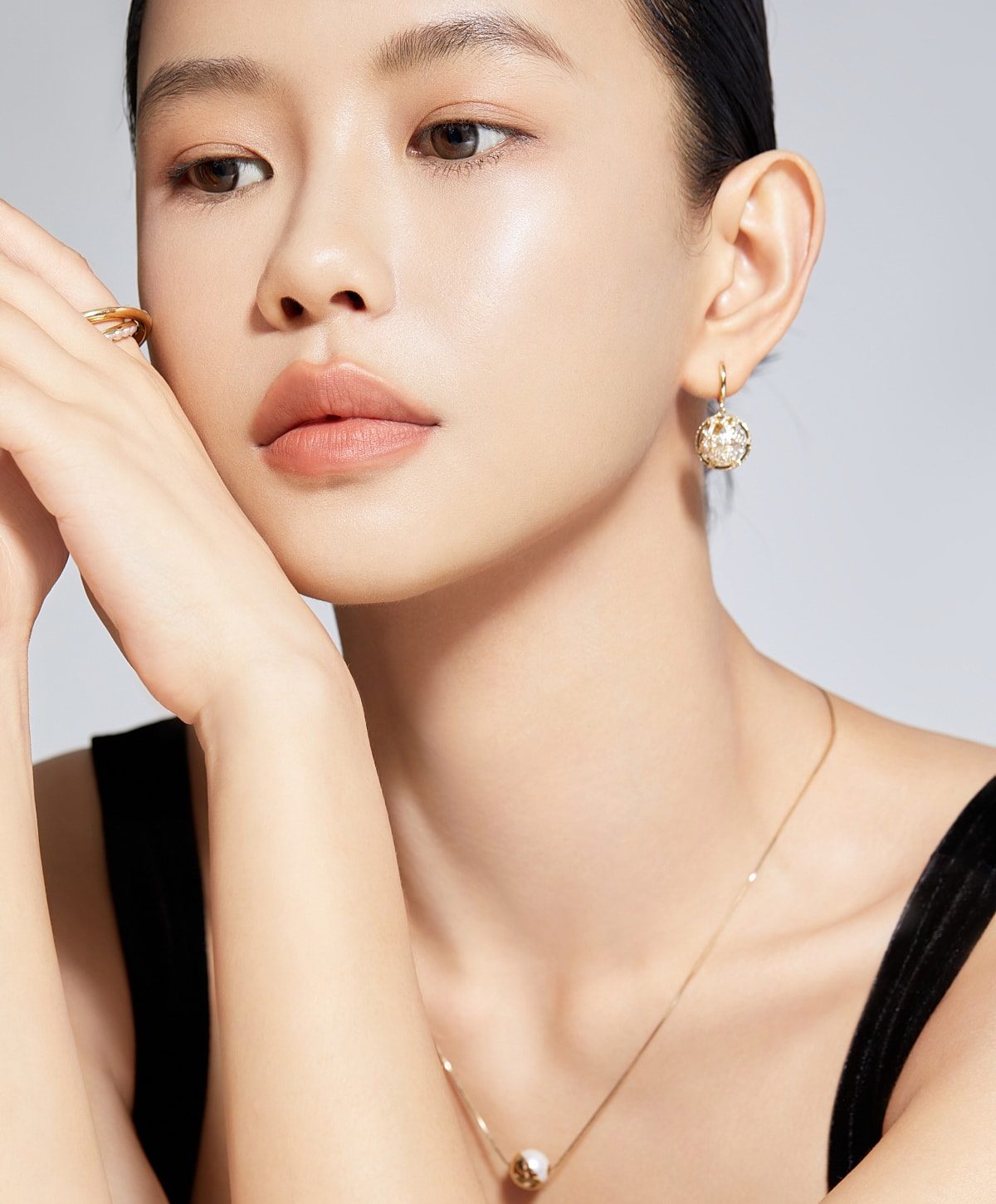 Model showcasing elegant earrings and necklace.