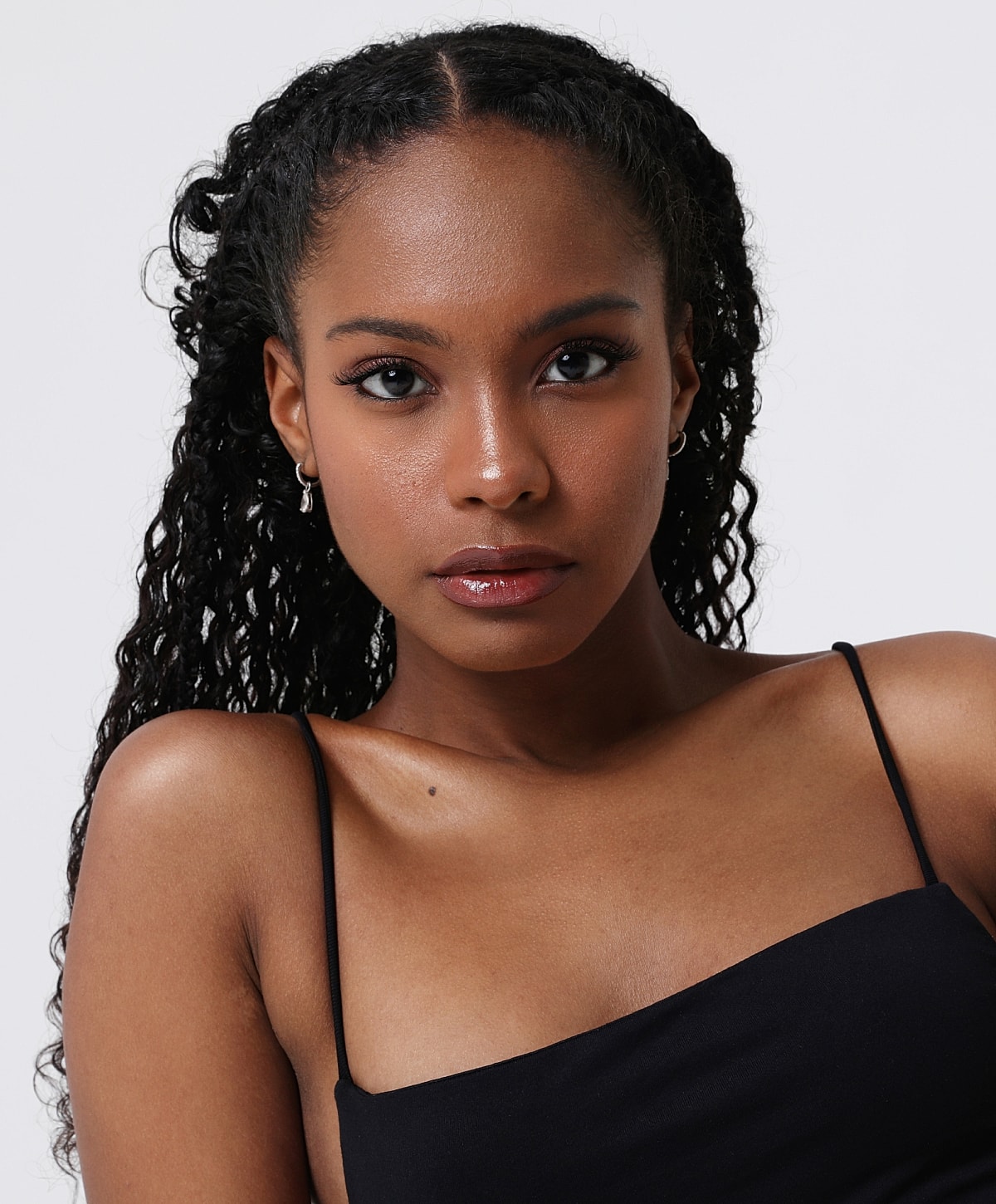Woman with curly hair in black outfit.