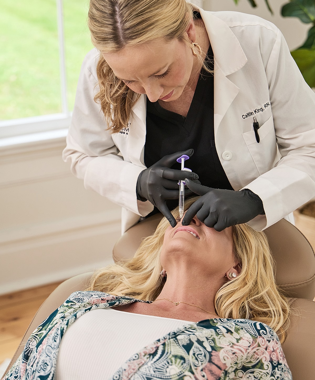 Nurse administering injectable treatment to patient.