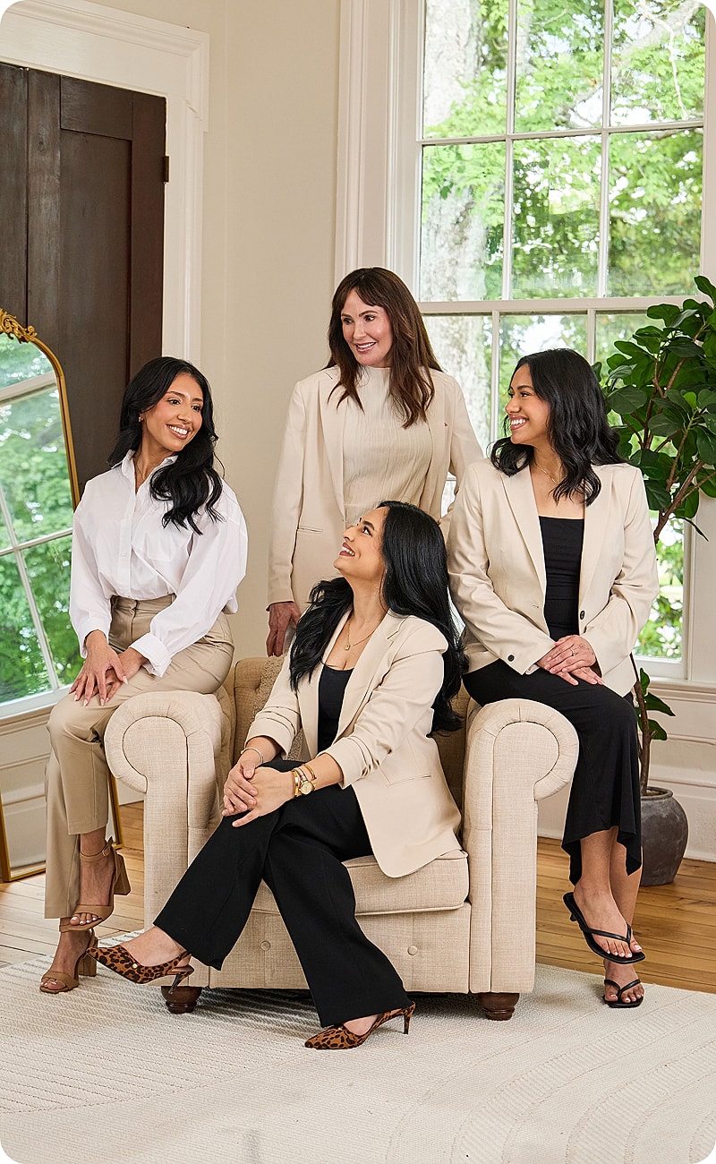 Group of women posing together in stylish outfits.