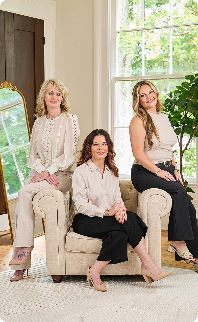 Three women seated in a cozy living room.
