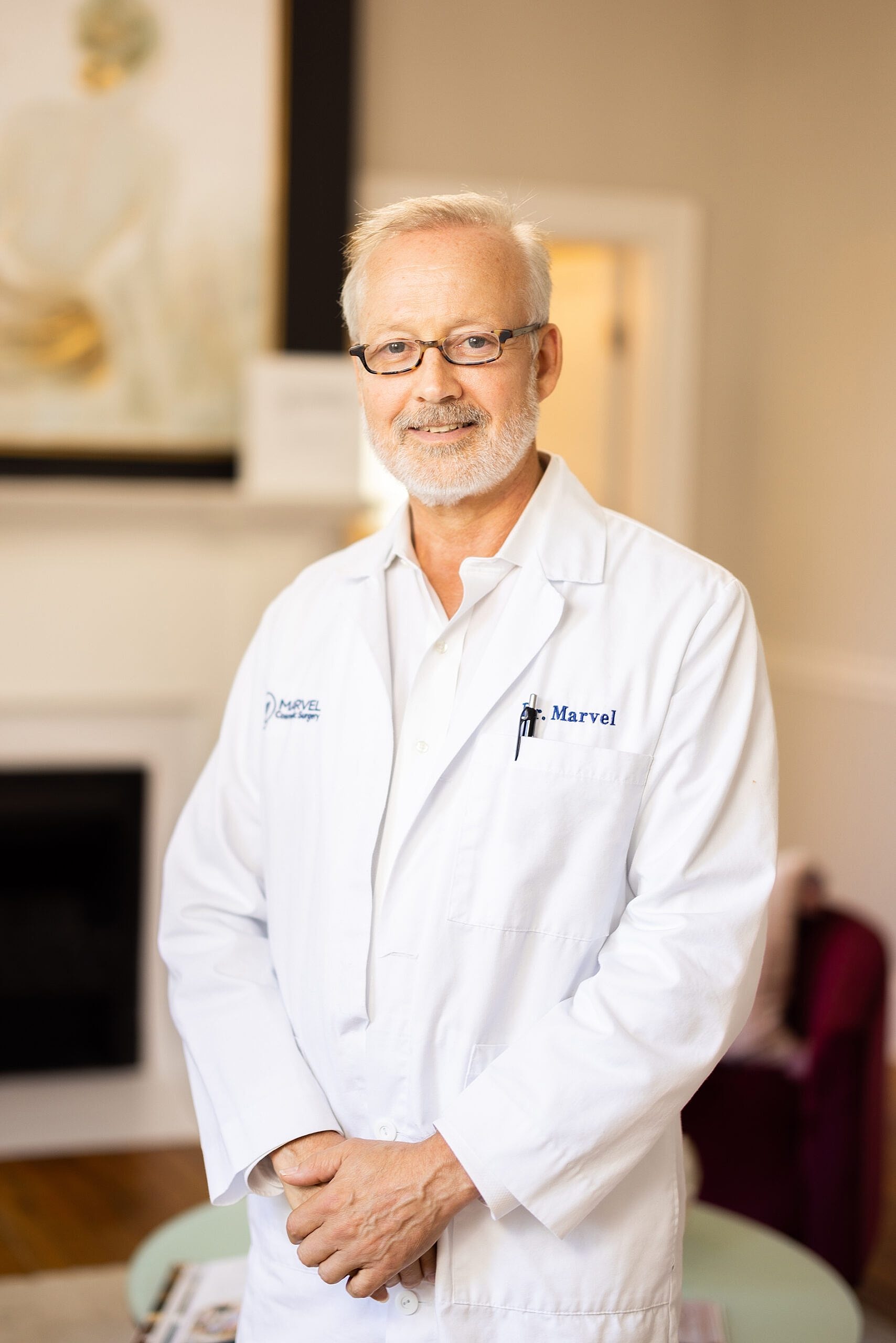 Male doctor in white coat, smiling confidently.
