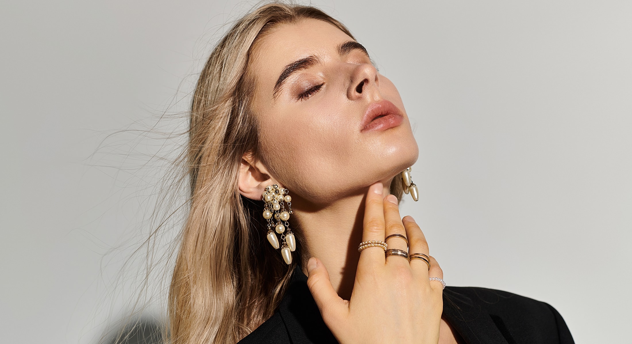 Model showcasing elegant jewelry with neutral background.