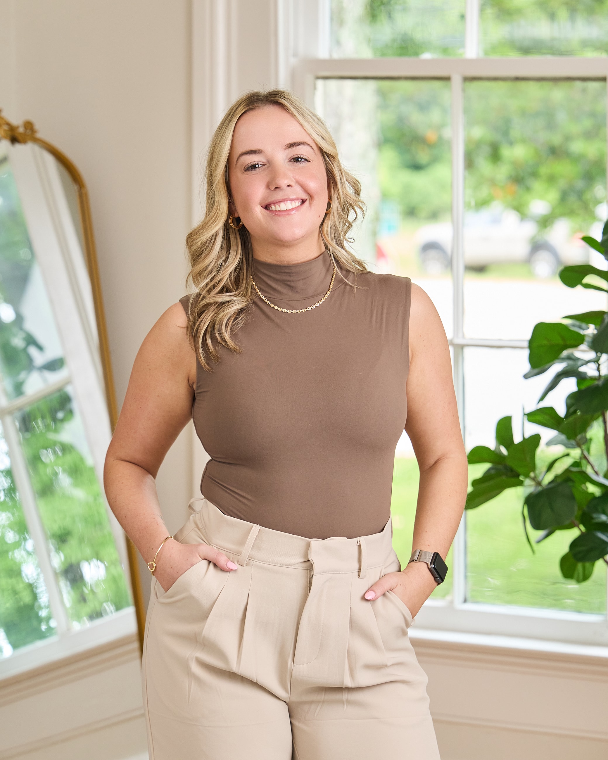 Smiling woman in stylish outfit indoors.
