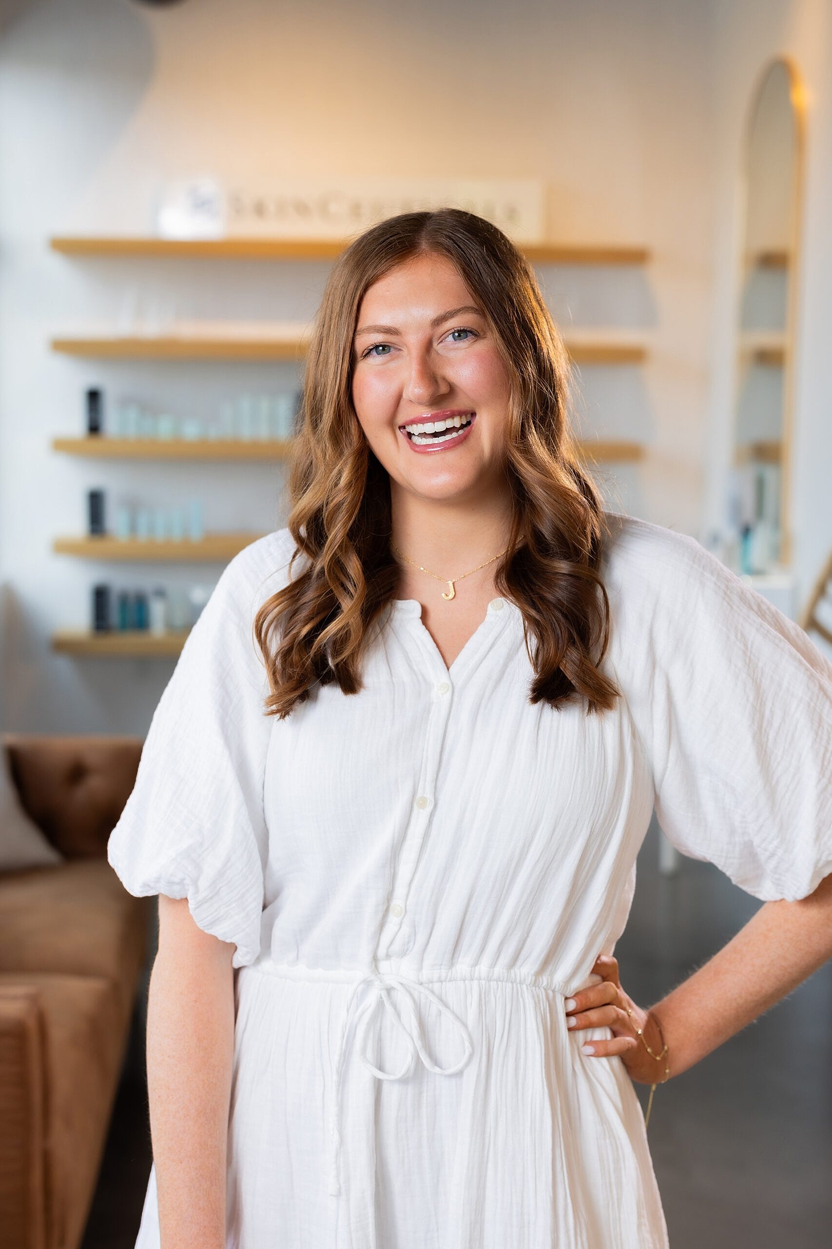 Smiling woman in a bright, stylish setting.