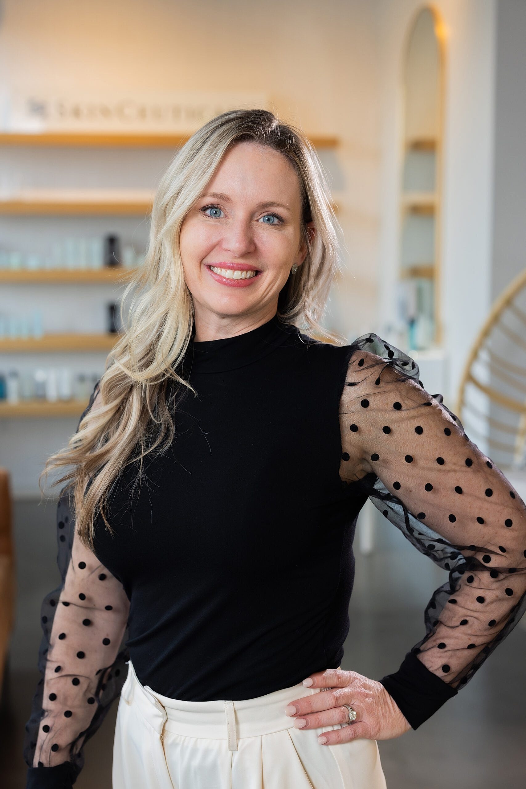 Woman smiling in stylish black and white outfit.